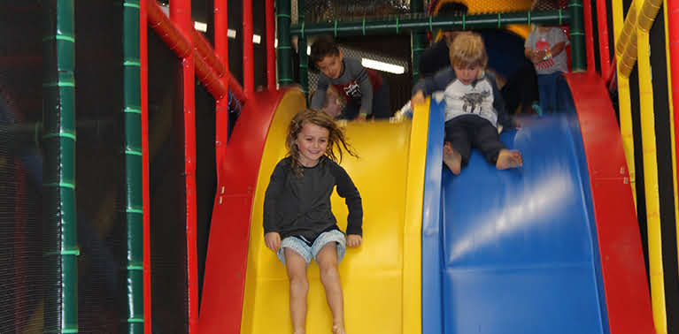 Children using the double slide in the play area