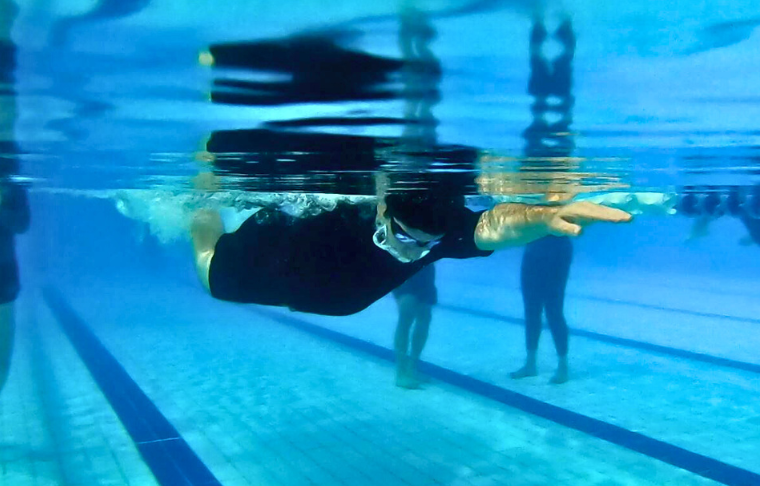 Swimmer underwater completing a stroke.