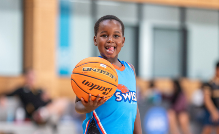 Little boy smiling with a basketball.