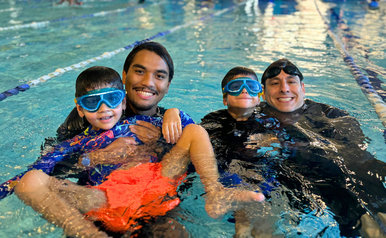 Two students with two instructor's in the water.