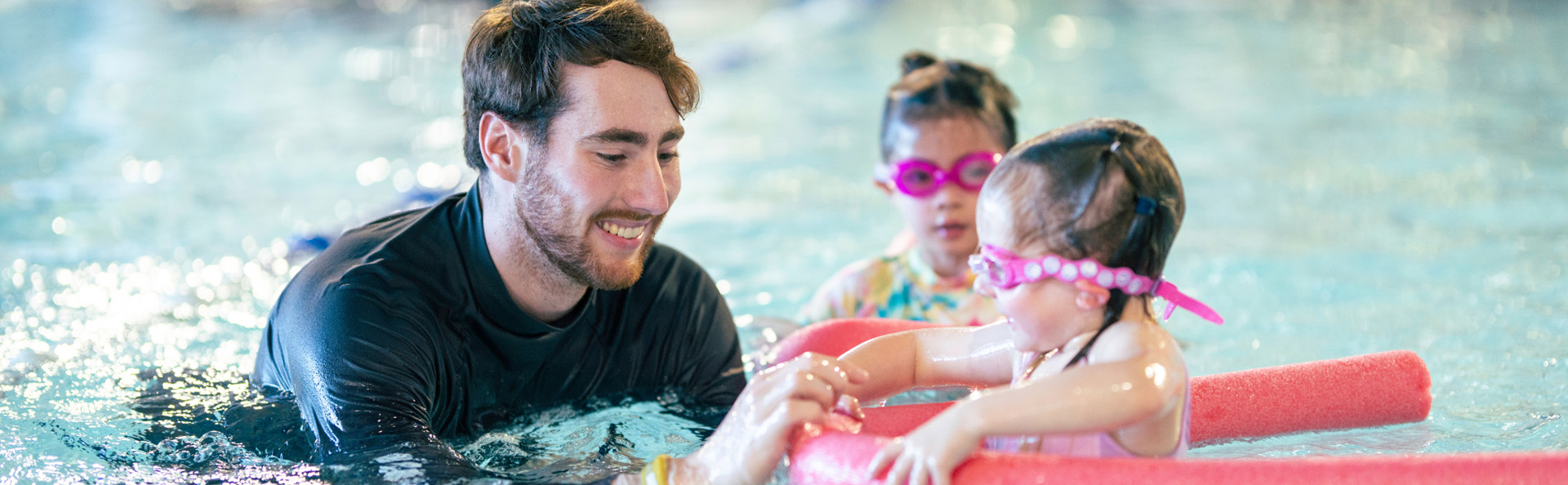 Little girl enjoying swim lesson with instructor