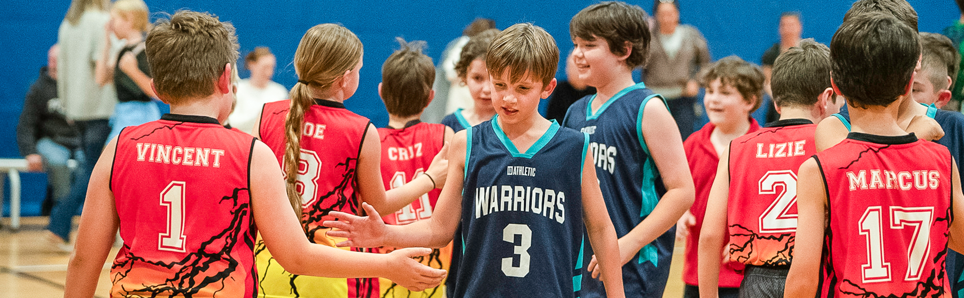 Kids congratulating each other after a basketball game