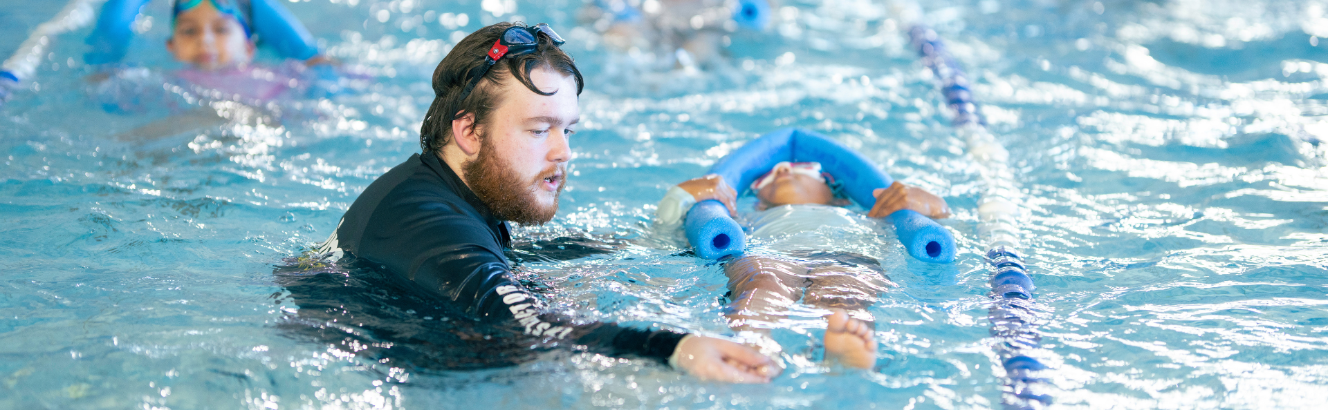 instructor with child swimming