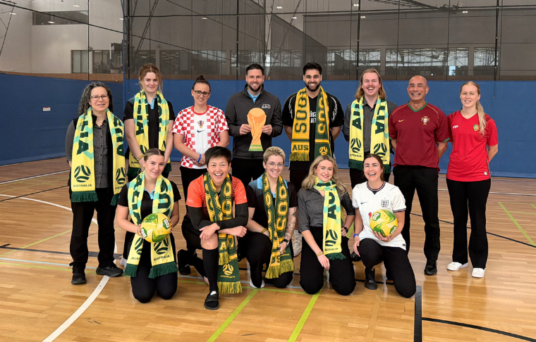 Patrons standing together in unison wearing their soccer team colours. 