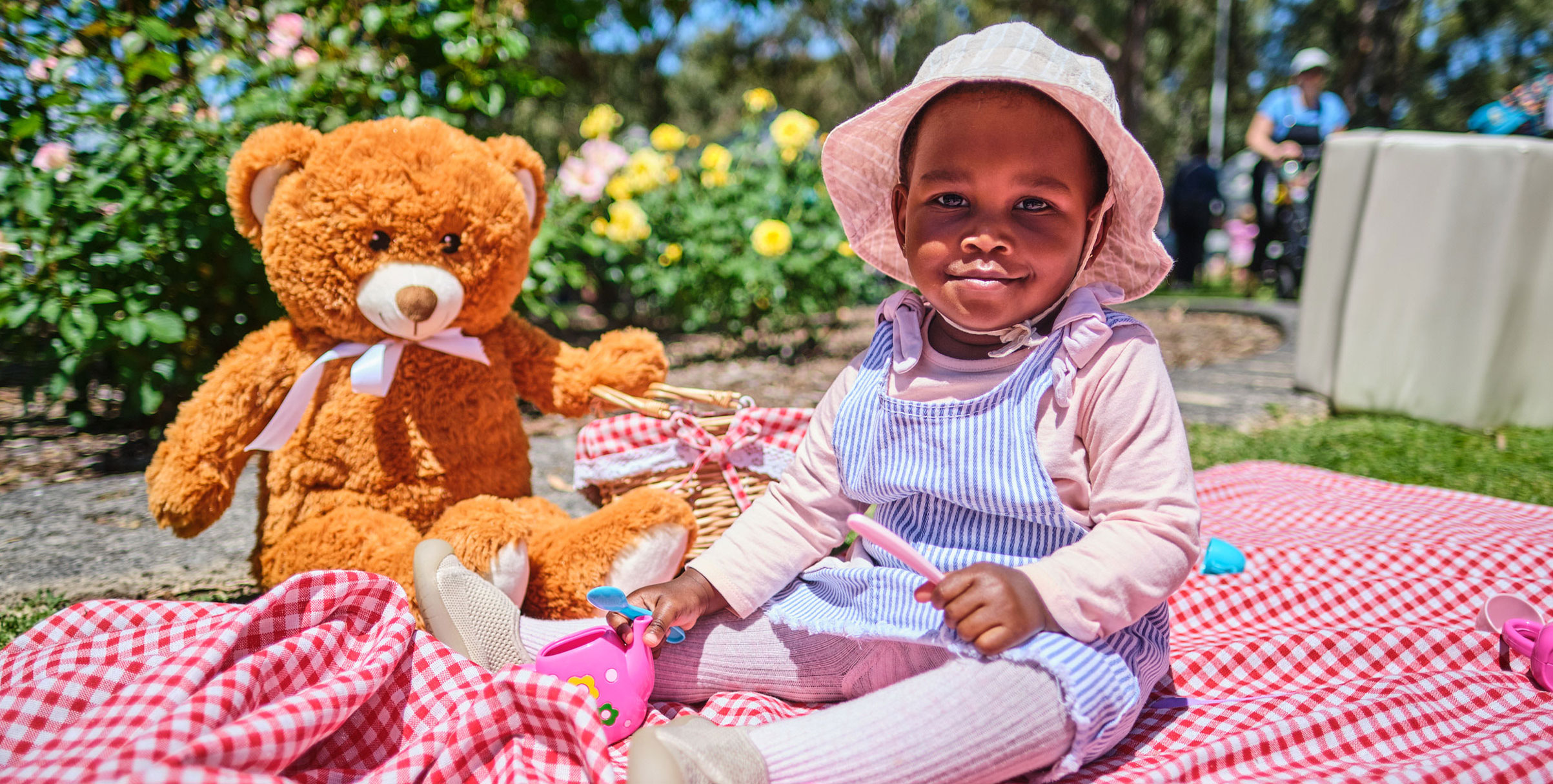 Baby on a picnic rug with teddy bear